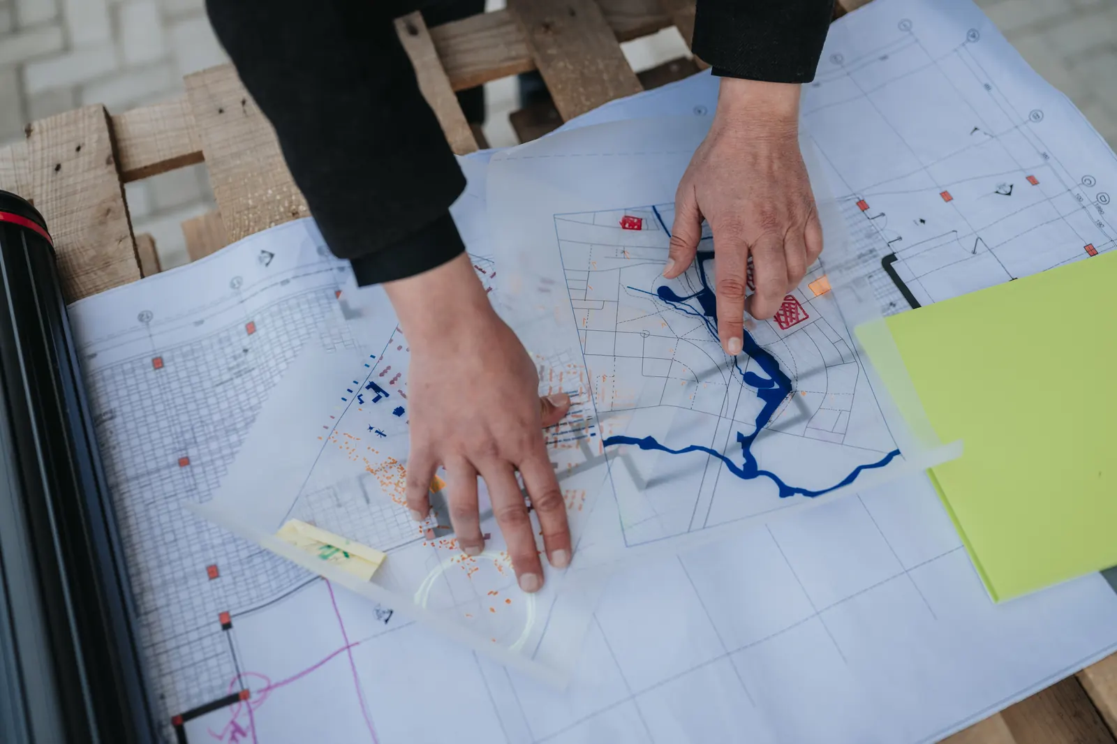 Hands reviewing planning documents on a desk