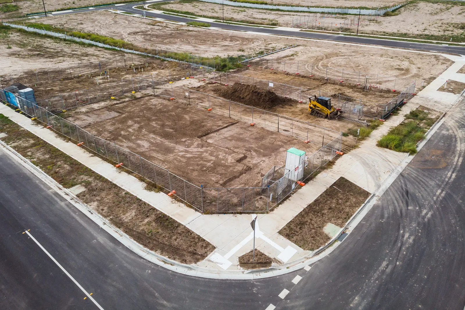 Aerial view of cleared subdivision lots beside a new road